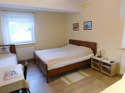 a room with a bed and a chair and a table at KAJA Zawoja in Zawoja
