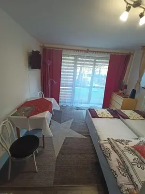 a bedroom with two beds and a table and a window at Pokoje u Zajdy in Zawoja