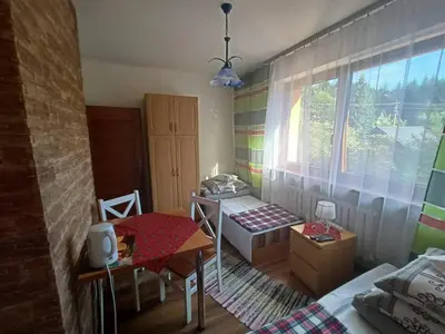 a bedroom with a bed and a table and a window at Pokoje u Zajdy in Zawoja