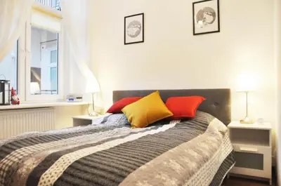 a bedroom with a bed with colorful pillows on it at Tenczyńska 4 by Homeprime in Kraków