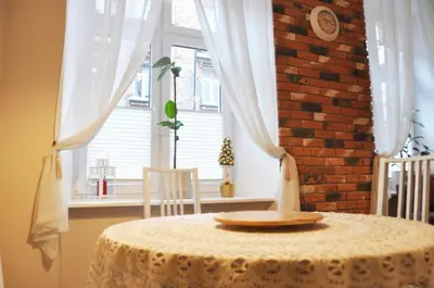 a table with a plate on it in front of a window at Tenczyńska 4 by Homeprime in Kraków