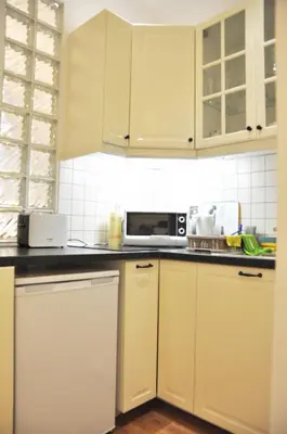 a kitchen with white cabinets and a microwave at Tenczyńska 4 by Homeprime in Kraków