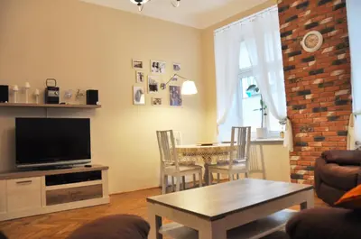 a living room with a television and a table with chairs at Tenczyńska 4 by Homeprime in Kraków