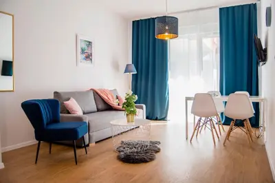 a living room with a couch and a table at Apartamenty Rakowicka WAWELOFTS in Kraków