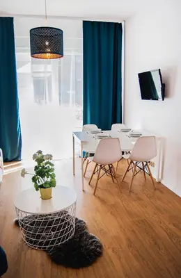 a dining room with a table and two chairs at Apartamenty Rakowicka WAWELOFTS in Kraków