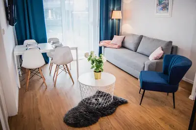 a living room with a couch and a table at Apartamenty Rakowicka WAWELOFTS in Kraków