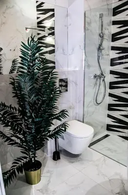 a bathroom with a toilet and a plant in it at Apartamenty Rakowicka WAWELOFTS in Kraków