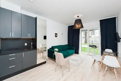 a living room with a green couch and a table at Apartamenty Rakowicka WAWELOFTS in Kraków