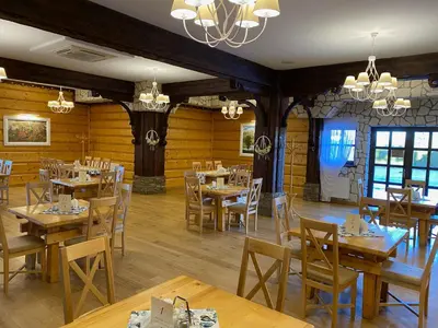a dining room with wooden tables and chairs at Hotel Tadeusz in Uszew