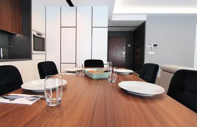 a long wooden table with plates and glasses on it at Lubicz Luxury Apartment in Kraków