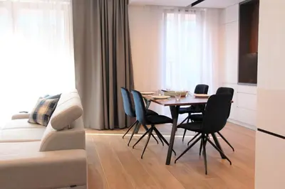 a living room with a table and chairs and a couch at Lubicz Luxury Apartment in Kraków