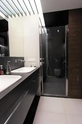 a bathroom with two sinks and a glass shower at Lubicz Luxury Apartment in Kraków