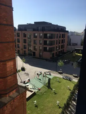 a playground in the middle of a courtyard with buildings at Lubicz Luxury Apartment in Kraków