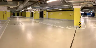 an empty parking garage with yellow walls and a concrete floor at Lubicz Luxury Apartment in Kraków