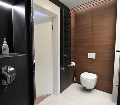a bathroom with a toilet and wooden walls at Lubicz Luxury Apartment in Kraków