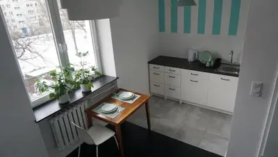 a small kitchen with a table and a sink at Lovely Bubbly Apartment in Kraków