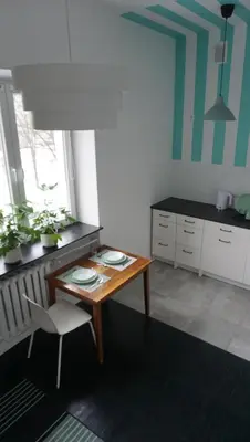 a kitchen with a table and a chair in a room at Lovely Bubbly Apartment in Kraków