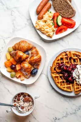 a table with three plates of breakfast food on it at Park Inn by Radisson Krakow in Kraków