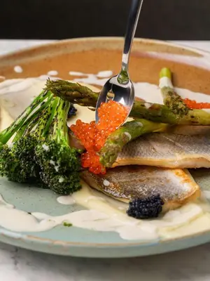 a plate of fish and vegetables with a fork at Park Inn by Radisson Krakow in Kraków