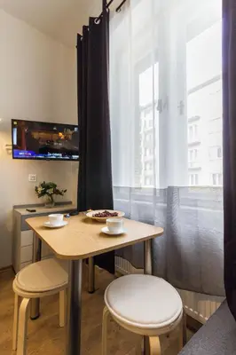a small room with a bed and a table and chairs at Nowy Kleparz Centrum Krakowa in Kraków