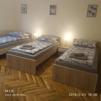 two twin beds in a room with wood floors at Apartament Sofia Agroturystyka in Ryczów