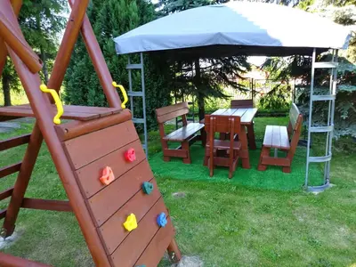 a playground with a table and chairs and an umbrella at Apartament Sofia Agroturystyka in Ryczów
