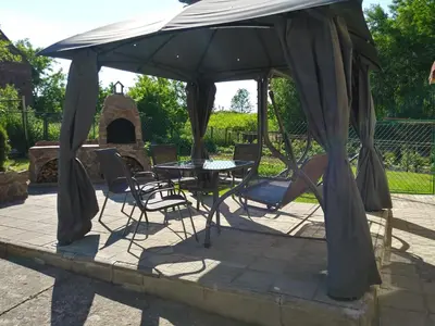 a table and chairs under an umbrella on a patio at Apartament Sofia Agroturystyka in Ryczów