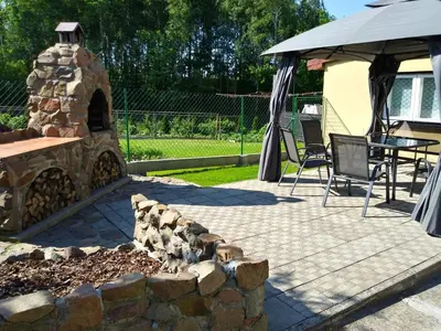 a patio with a stone fireplace and a table and chairs at Apartament Sofia Agroturystyka in Ryczów