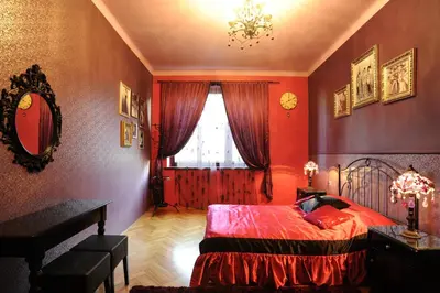a bedroom with a bed with red walls and a window at Hostel Deco in Kraków