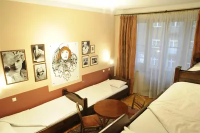 a room with two beds and a table and chairs at Hostel Deco in Kraków