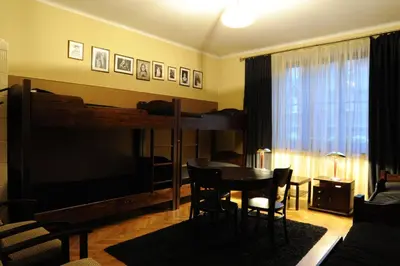 a living room with a table and a large television at Hostel Deco in Kraków