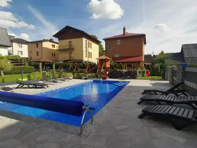 a swimming pool with chairs and a slide at Willa Cicha in Rabka