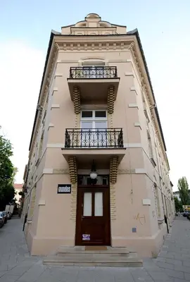 a tall building with a door and a balcony at Crystal Suites Old Town in Kraków