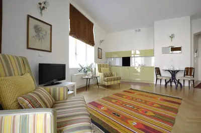 a living room with a couch and a tv at Crystal Suites Old Town in Kraków