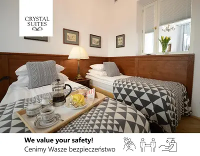 a hotel room with two beds and a tray of food at Crystal Suites Old Town in Kraków