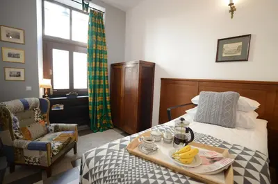 a bedroom with a bed with a tray of food on it at Crystal Suites Old Town in Kraków