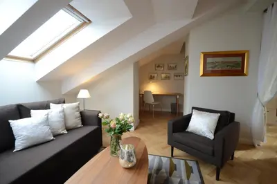 a living room with a black couch and a table at Crystal Suites Old Town in Kraków