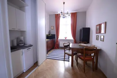 a kitchen and dining room with a table and chairs at Crystal Suites Old Town in Kraków