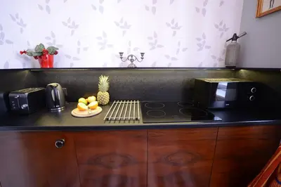 a kitchen with a counter with a stove and a plate of fruit at Crystal Suites Old Town in Kraków