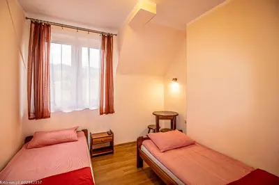 two beds in a room with a window at Dom Wypoczynkowy Modrys in Zawoja