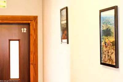 a hallway with a door and a painting on the wall at Dom Wypoczynkowy Modrys in Zawoja