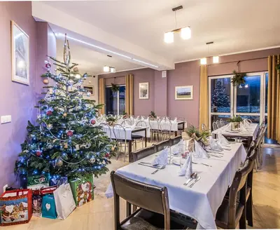 a christmas tree in a dining room with tables at Dom Wypoczynkowy Modrys in Zawoja