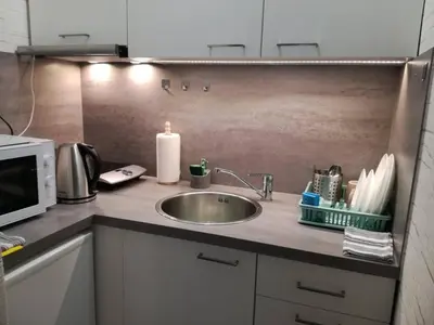 a kitchen counter with a sink and a microwave at Kremerowska Apartment in Kraków