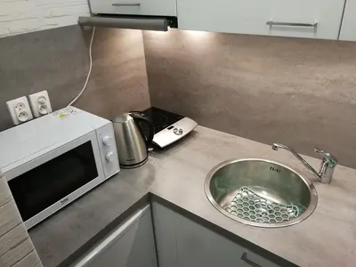 a kitchen counter with a sink and a microwave at Kremerowska Apartment in Kraków