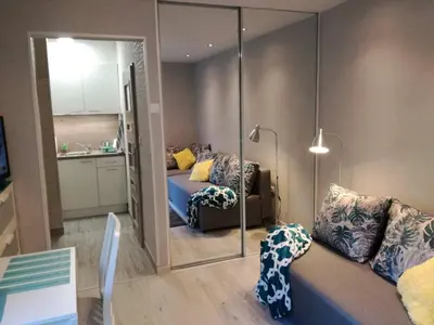 a living room with a bed and a mirror at Kremerowska Apartment in Kraków