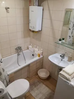 a bathroom with a tub and a toilet and a sink at Kremerowska Apartment in Kraków