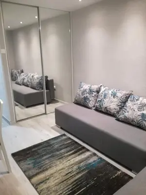 a living room with a couch and a mirror at Kremerowska Apartment in Kraków