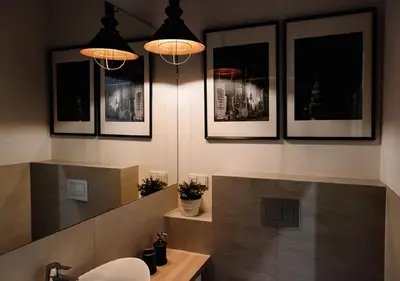 a bathroom with three lights and a sink in it at Memory Apartments in Kraków