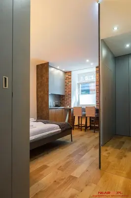 a bedroom with a bed and a kitchen at Old Town Topolowa 48 in Kraków