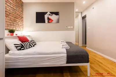 a bedroom with a white bed and a brick wall at Old Town Topolowa 48 in Kraków